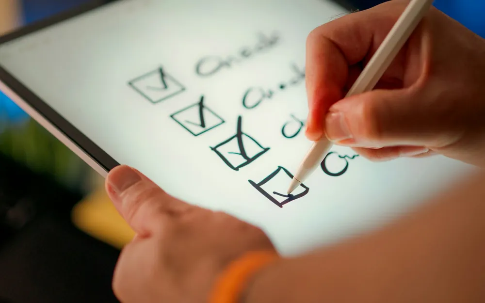 Mano marcando una lista de revisión en una tablet