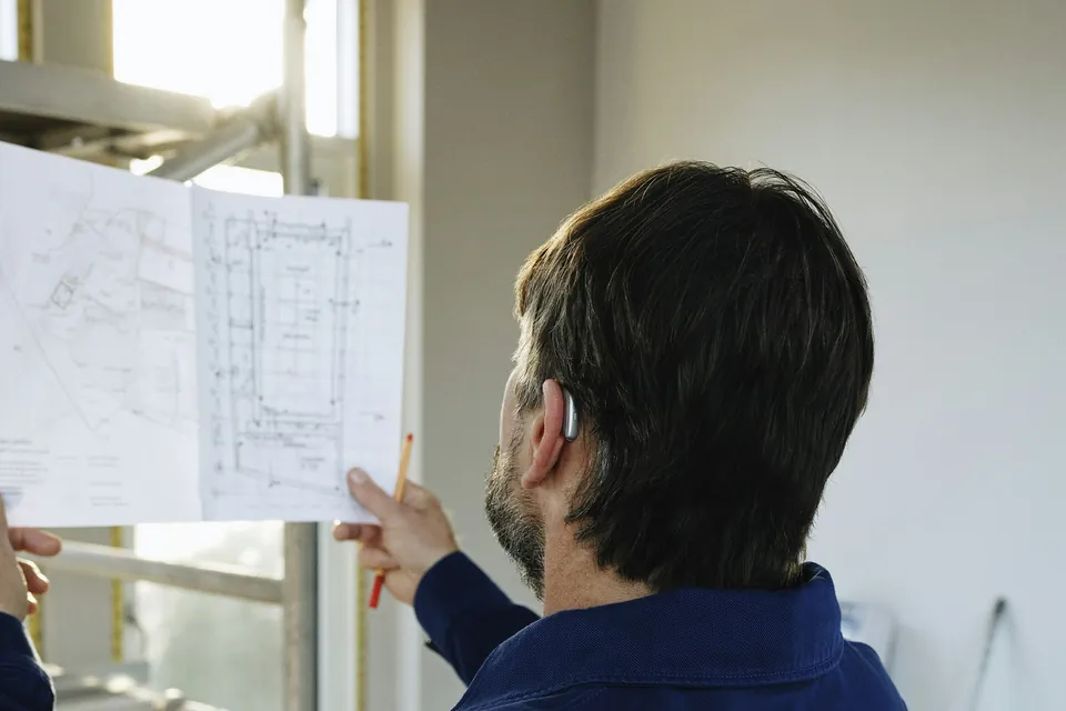 Técnico revisando planos durante la inspección de una vivienda
